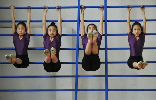 Девочек в китайской гимнастической школе гнут в бараний рог