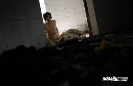 У Гуйлинь, наркоман в провинции Гуандун Китая, рубашки и тощий внутри своего ветхого дома.