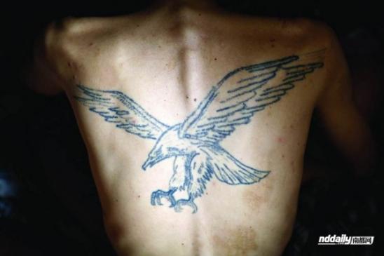 У Гуйлинь, наркоман в провинции Гуандун Китая, с орлом татуировку на спине.