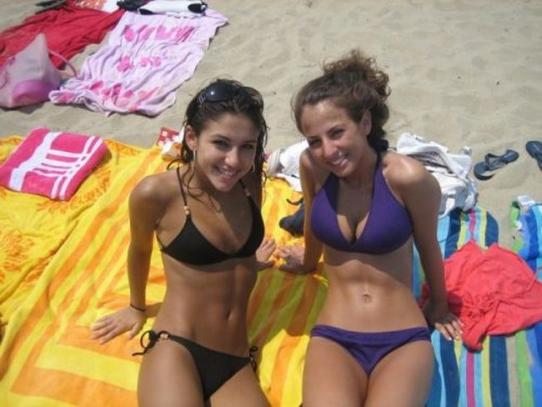 Симпатичные девушки в бикини отдыхают на пляже